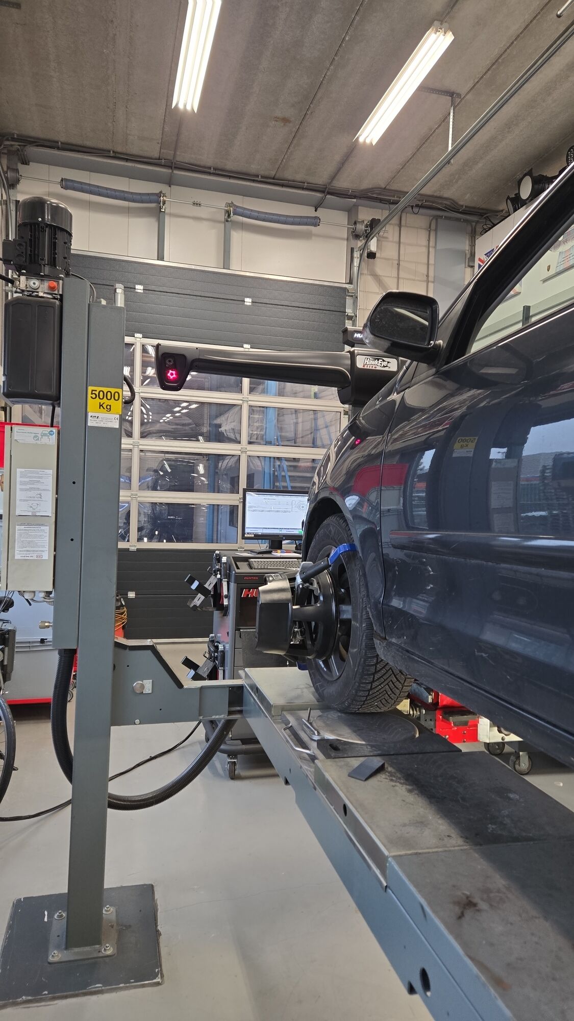 Auto op de uitlijnbrug in de werkplaats